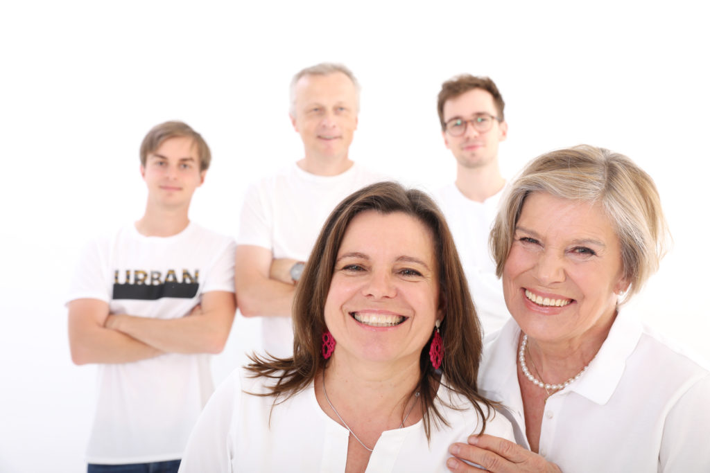 Moderne Familienaufnahme mit farblich abgestimmten Outfits, Großeltern  auf weißem Hintergrund. Fotoshooting mit der Familie in Wien: Die schönsten Ideen
