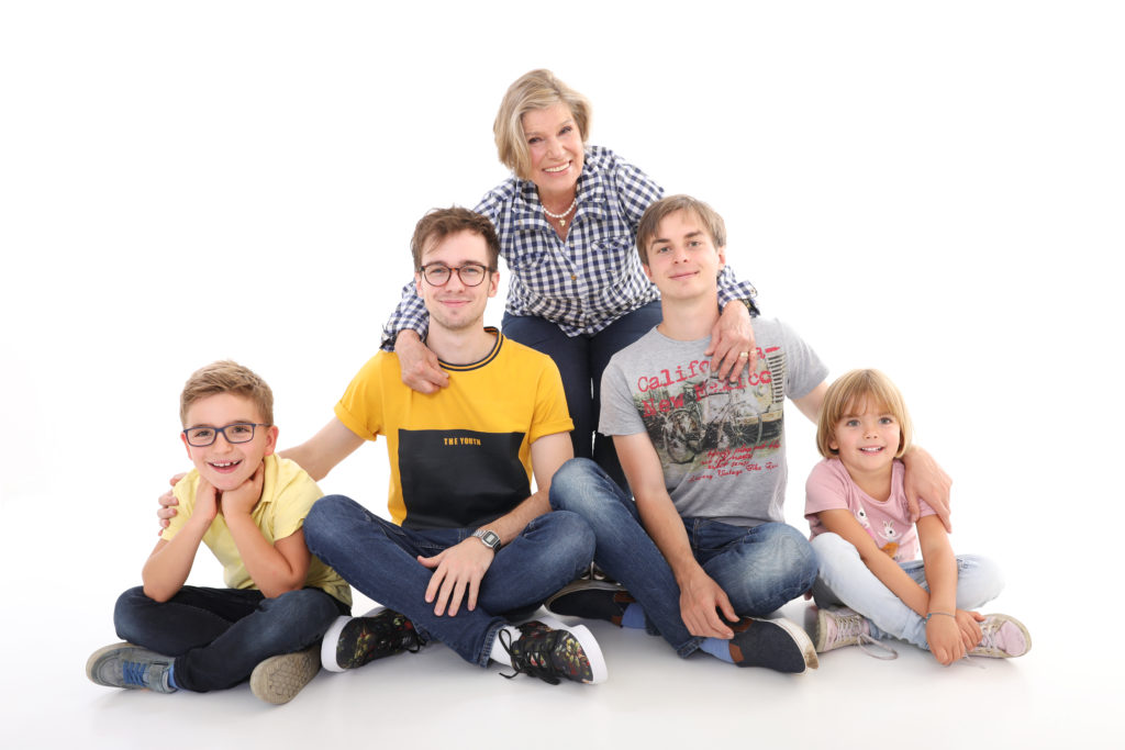 Moderne Familienaufnahme mit farblich abgestimmten Outfits, Großeltern  weißem Hintergrund. Fotoshooting mit der Familie in Wien: Die schönsten Ideen