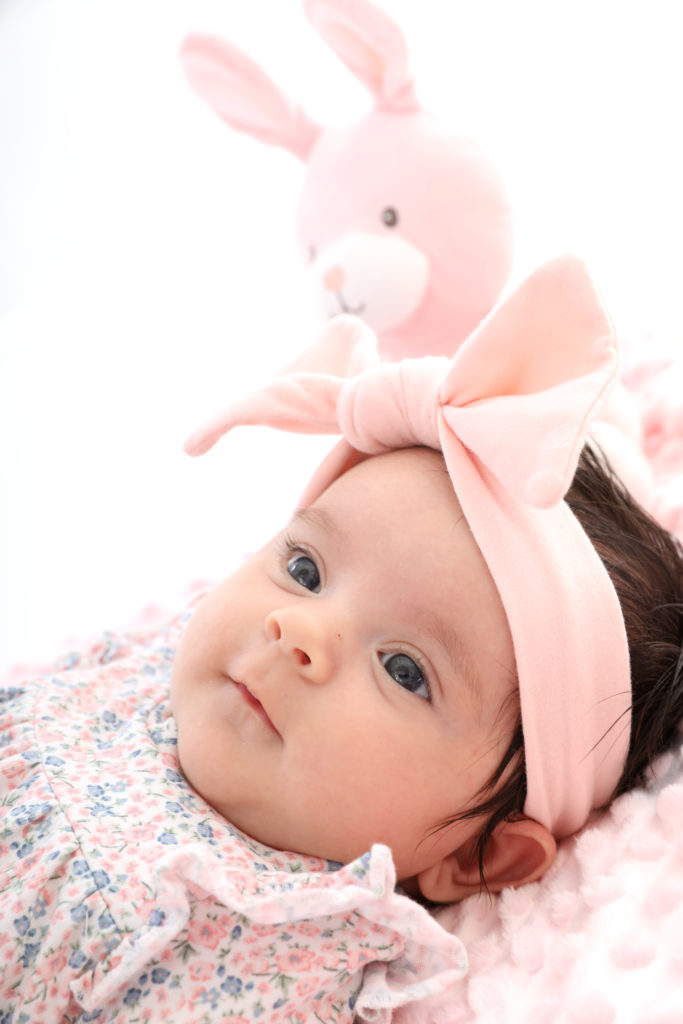 Echte Hingucker: Babyfotografie in Wien. Winzige einmonatige Baby-Mädchen in Rosa für Familienporträts