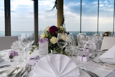 Elegantes Tischarrangement für eine Feier mit Blumenstrauß und Meerblick