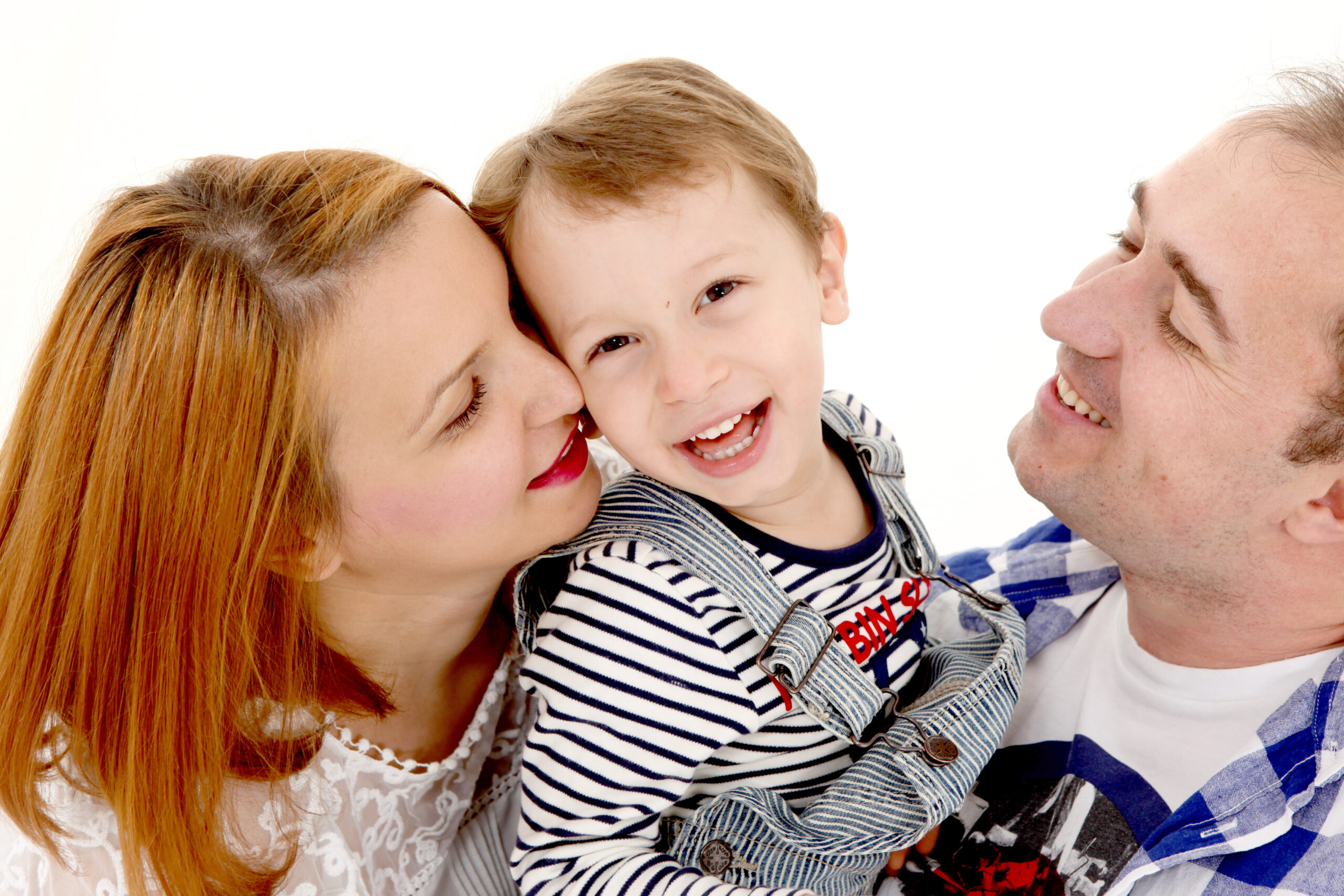Eine glückliche Familie mit Mutter, Vater und Sohn lächeln und kuscheln zusammen