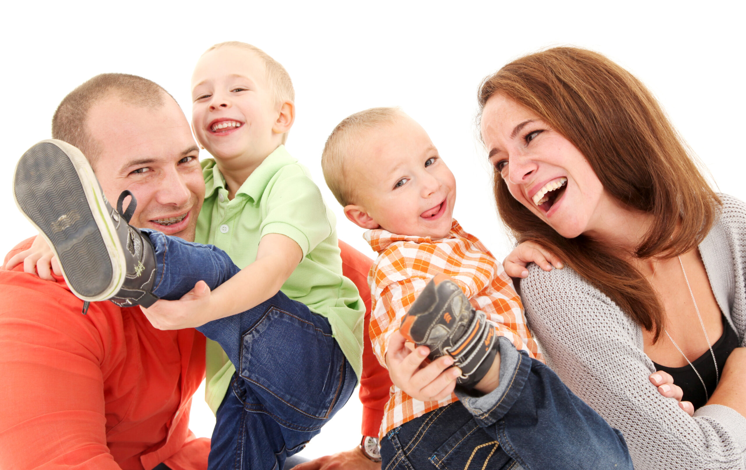 Eine fröhliche Familie spielt und lacht zusammen auf einem weißen Hintergrund.