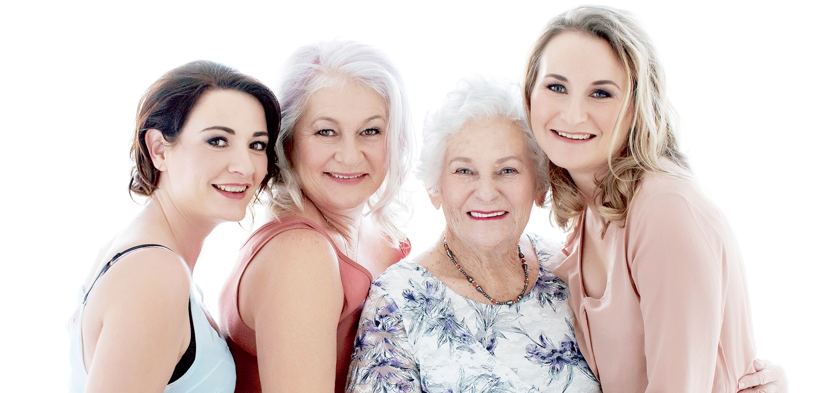 Vier lächelnde Frauen unterschiedlichen Alters vor einem hellen Hintergrund